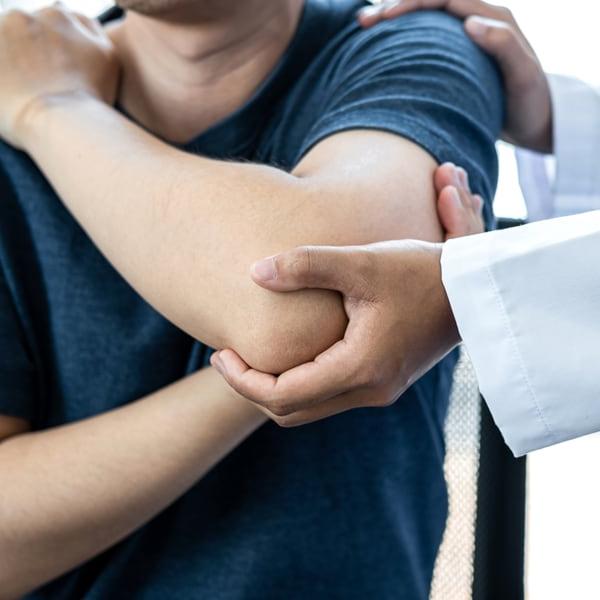 doctor with patient checking elbow